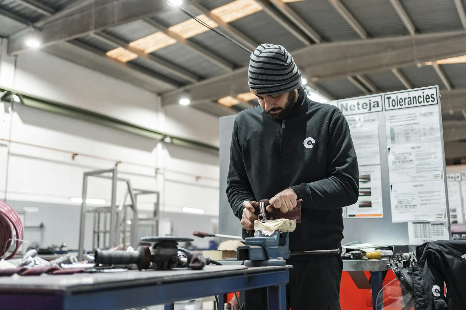Un lavoratore esegue una lavorazione manuale al banco in officina.